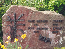 Familiengrabstein mit Bronzeschrift und Rosen